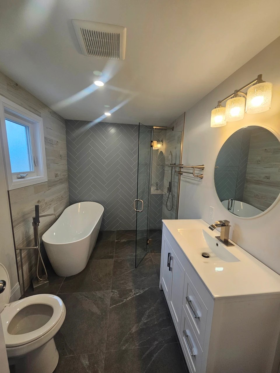 Freestanding bathtub in renovated bathroom by Ancaster Carpentry